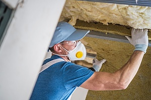 insulation professional working in insulating an attic in a home