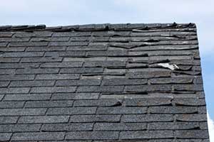 Damaged roof shingles needing a partial roof replacement