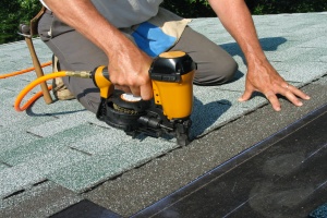 Man using nail gun in order to replace roof before selling home