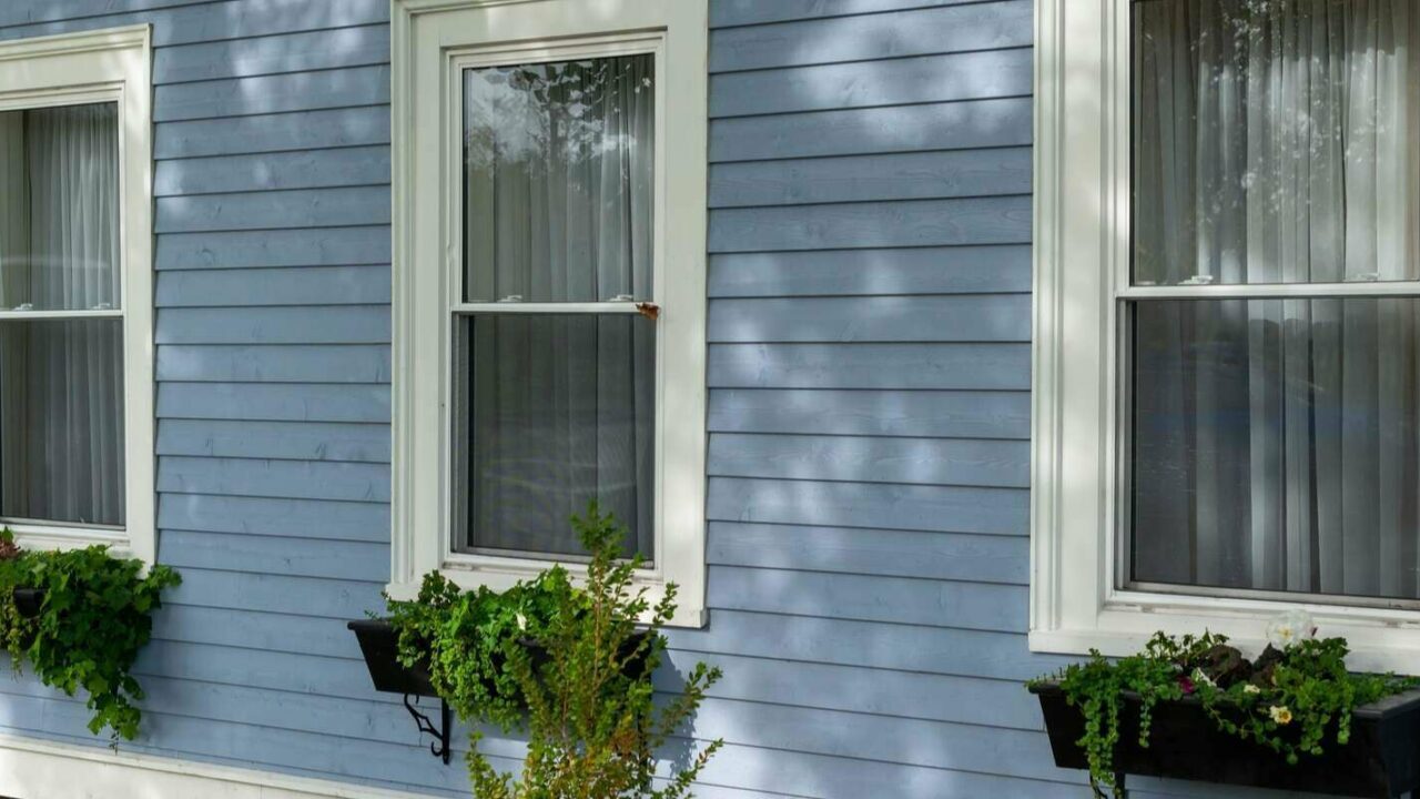 exterior wall of a building with three tall double hung windows