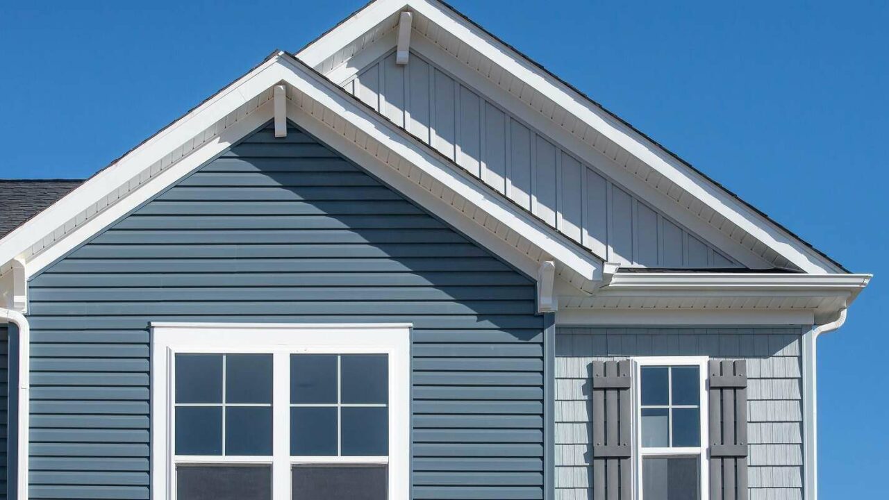 vertical siding in a double gable roof with white decorative corbels