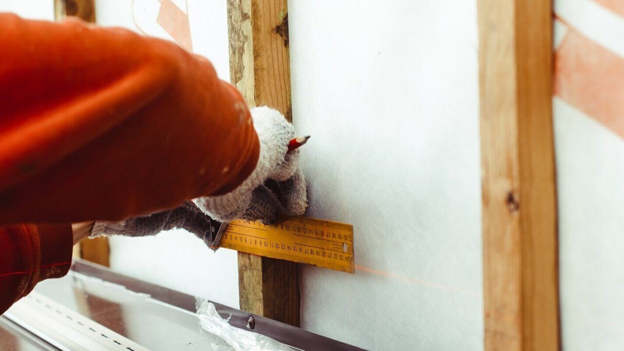 professional siding contractor makes measurements when installing the siding