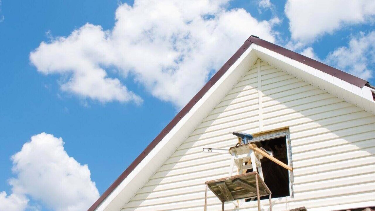 installation of a siding on a house against the sky