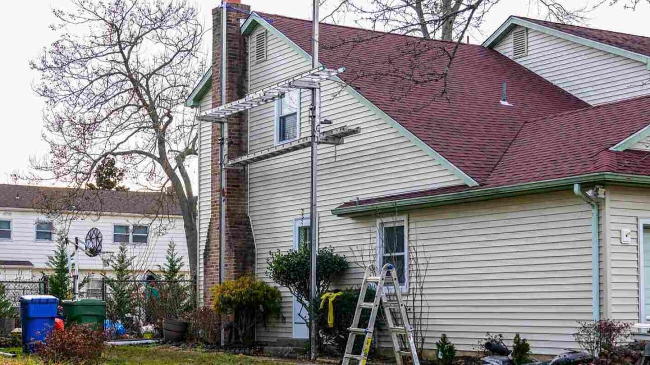 scaffolding and ladder set up on the side of a home to allow residing of the house