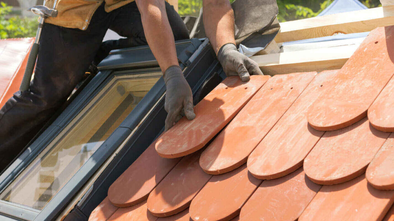 roofer laying tile on the roof