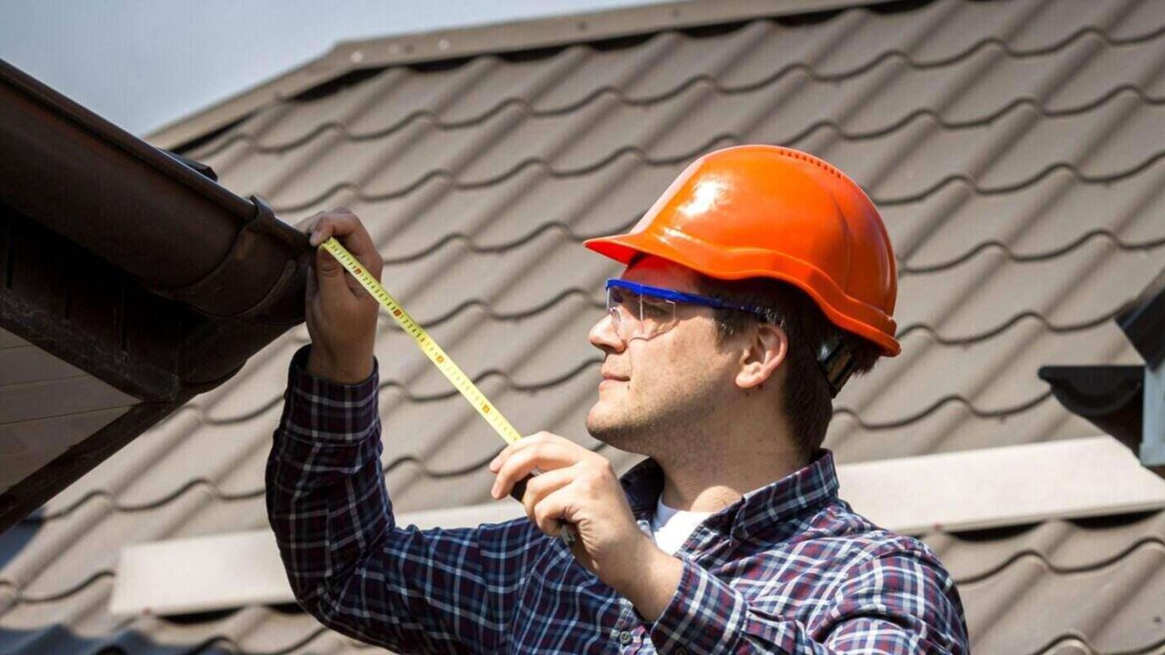 man measuring roof with measuring tape