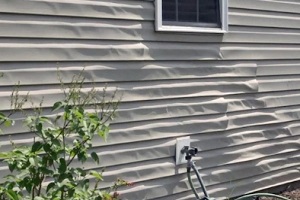 warped vinyl siding in home backside